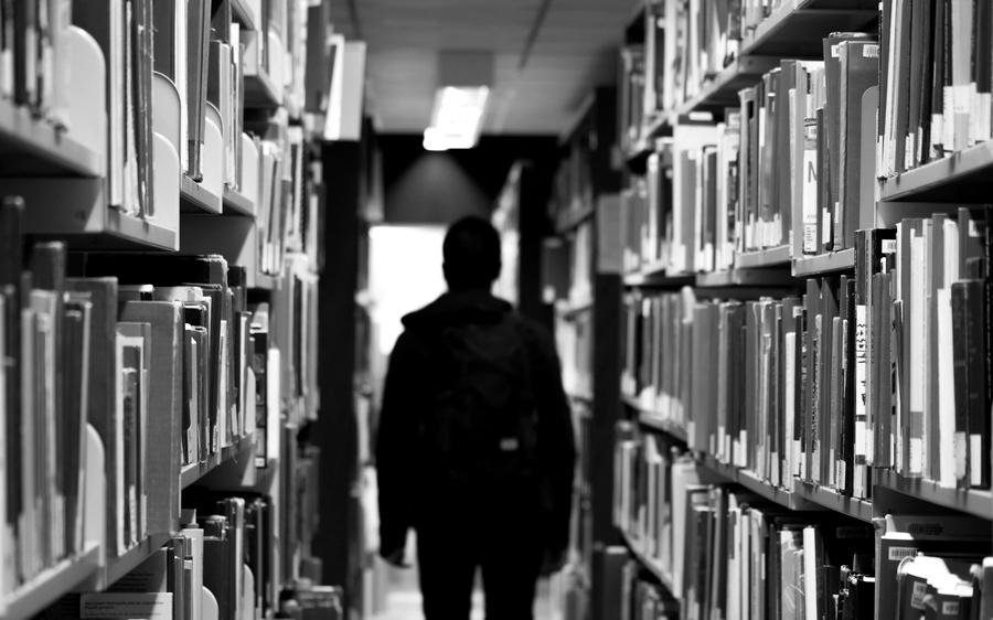 A student between library stacks
