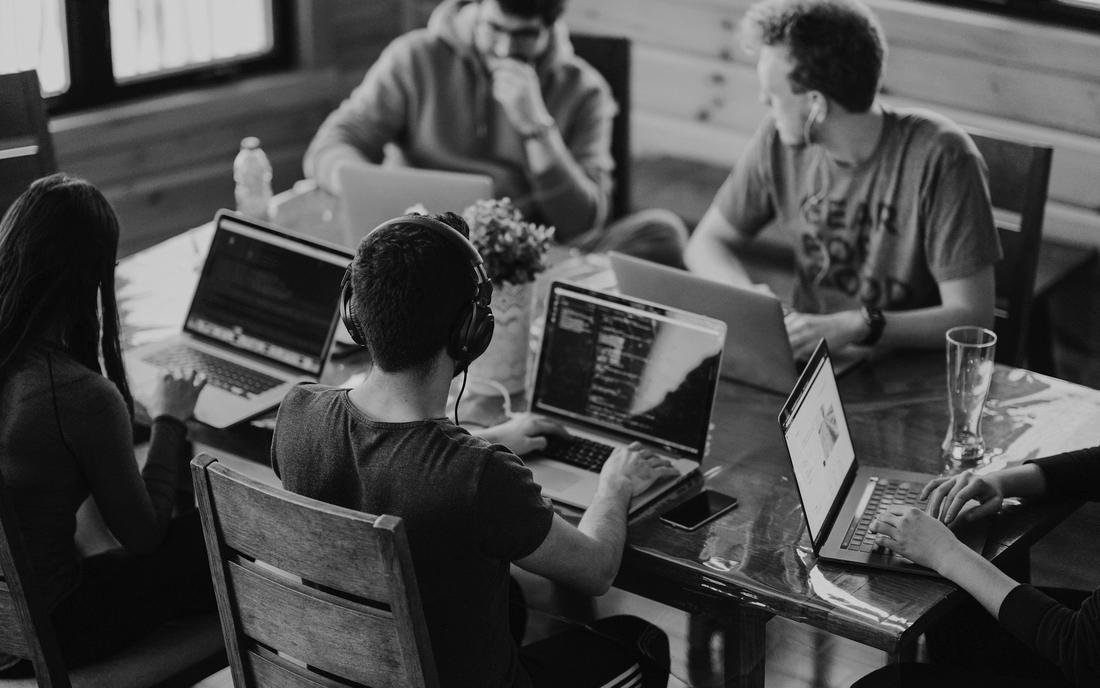 A team working around a table with laptops