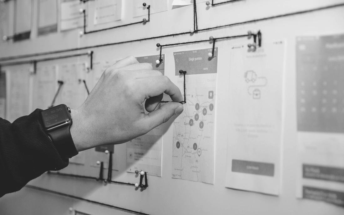 A hand writing on a wall of planning notes